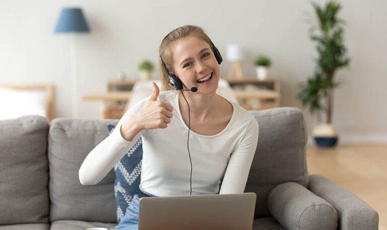 A smiling woman wearing a headset and studying a Japanese tutor 7